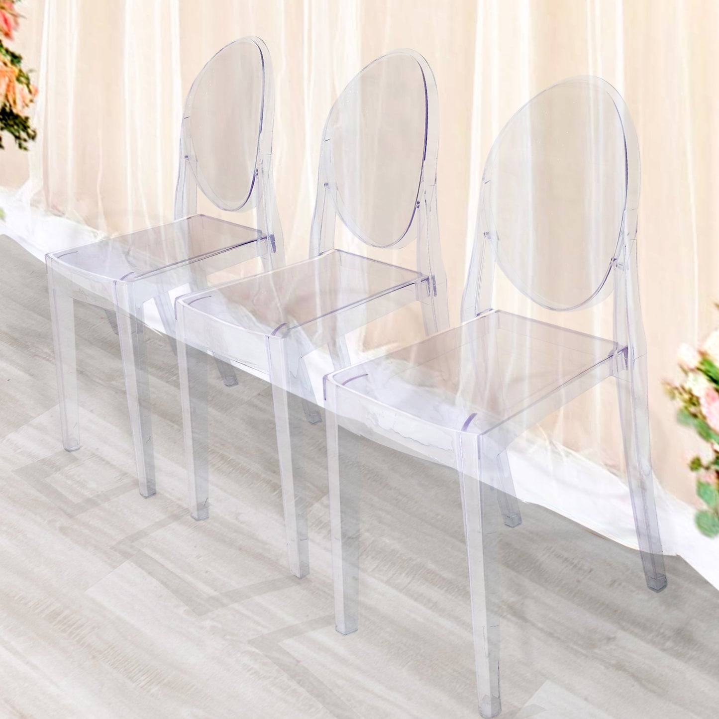 Clear acrylic stackable ghost banquet chairs with oval backs.