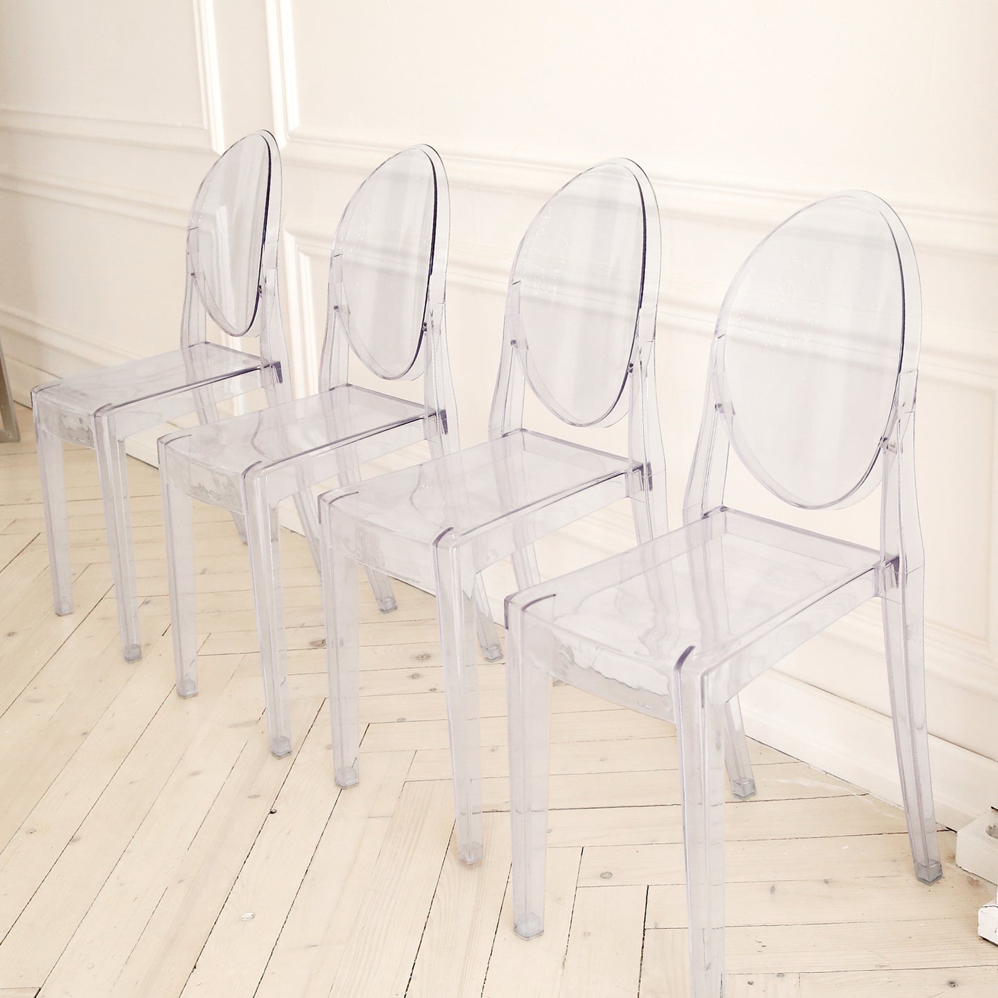 Clear acrylic ghost chairs with oval backs, fully assembled and stackable.