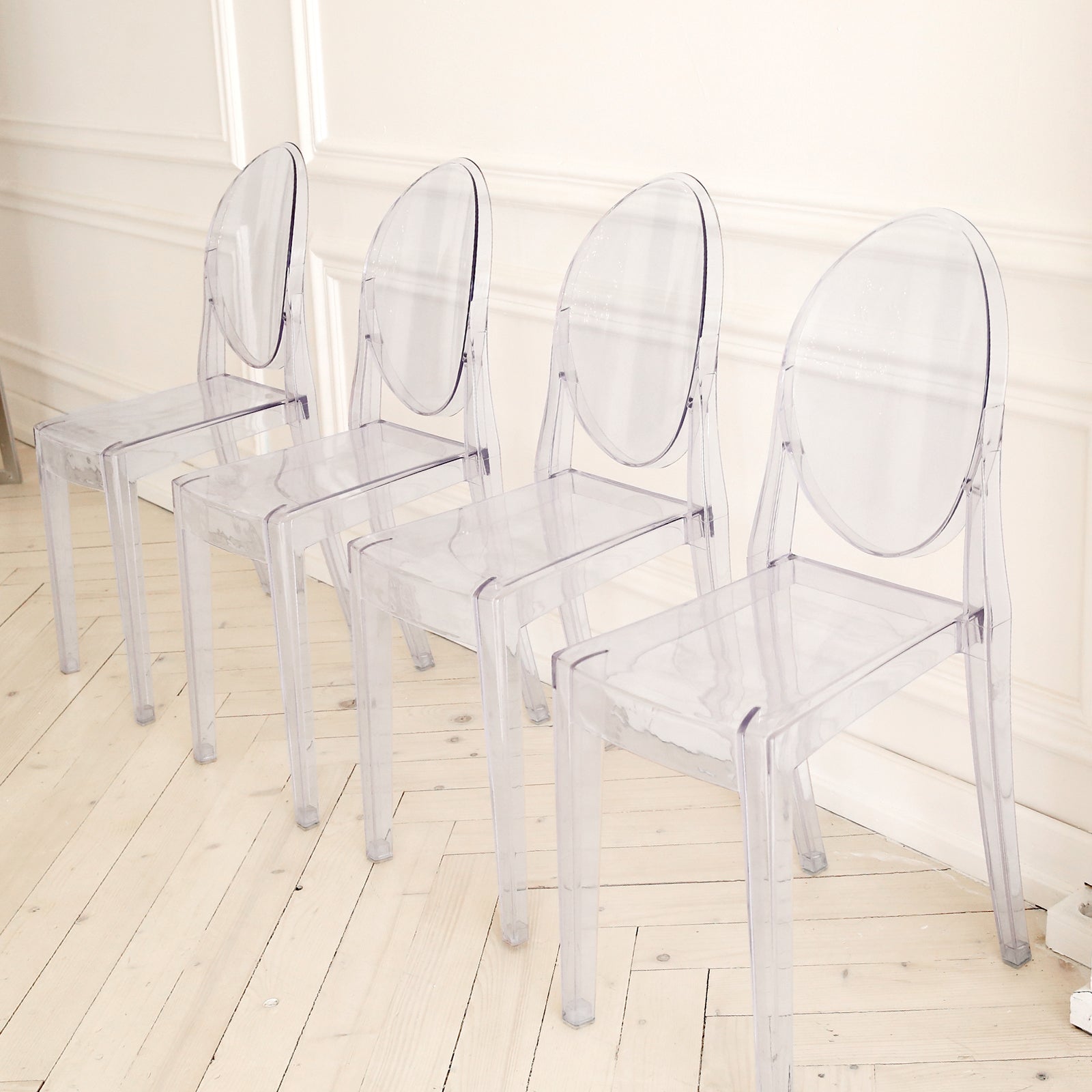 Clear acrylic ghost chairs with oval backs, fully assembled and stackable.