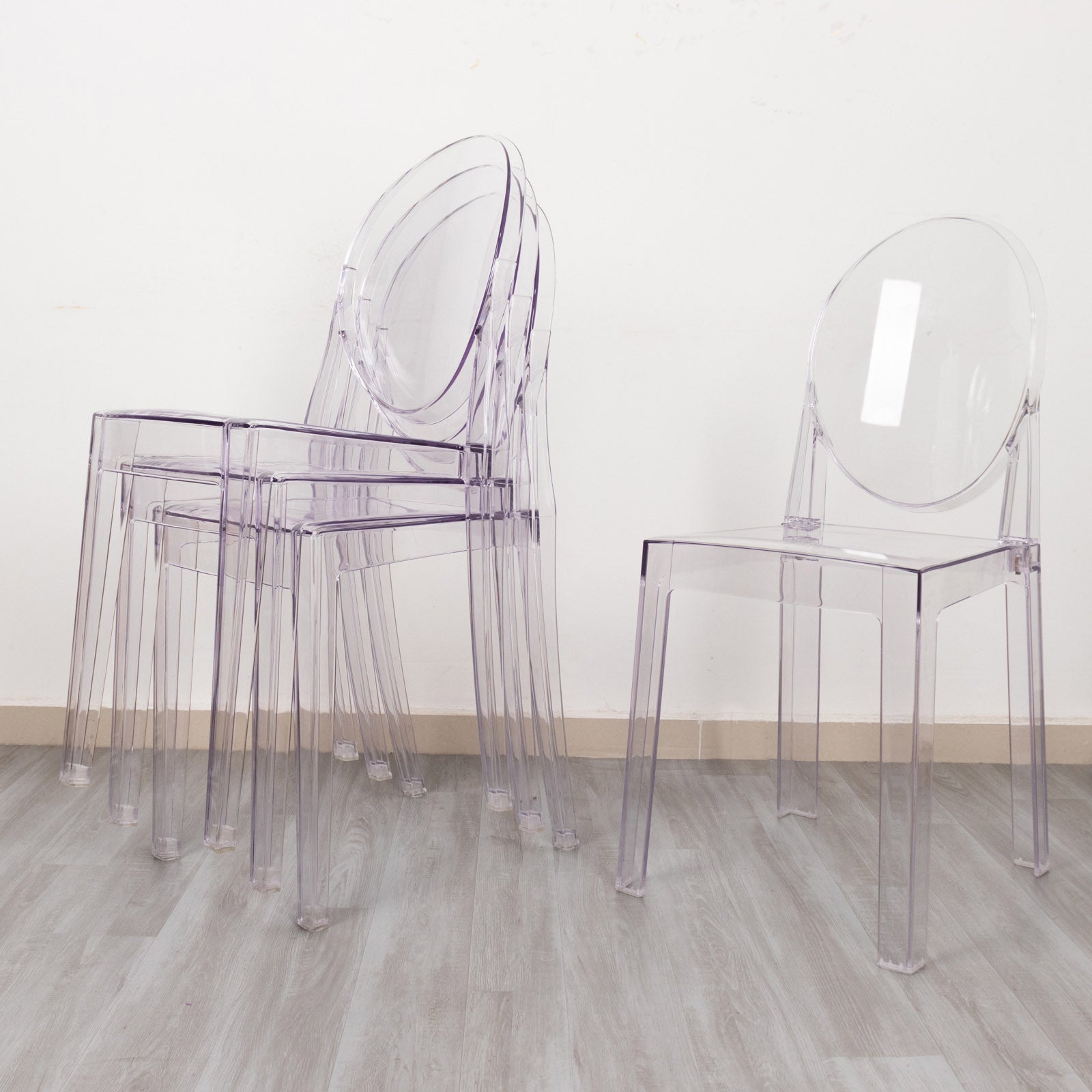 Stackable clear acrylic ghost banquet chairs with oval back.