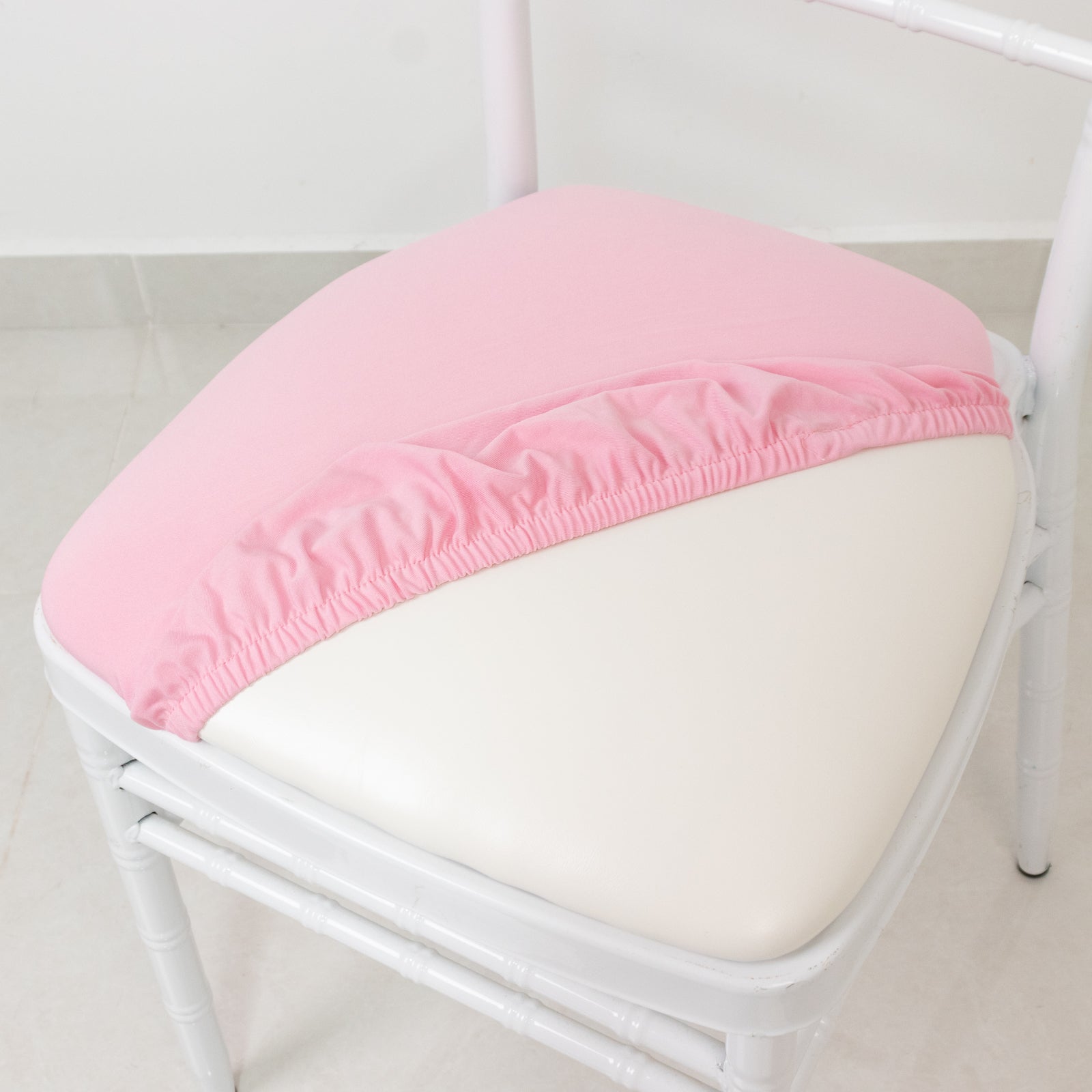 Pink spandex seat pad slipcover for Chiavari chair, fitted and washable.