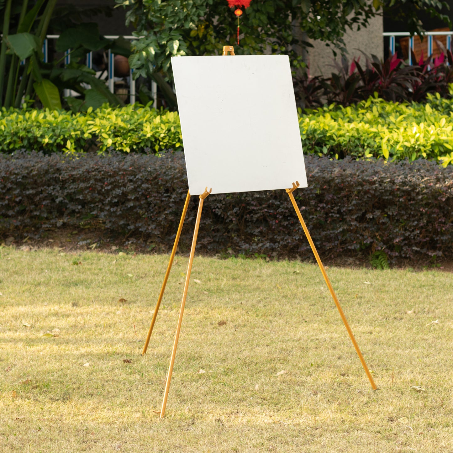 Gold metal easel stand for wedding signs and posters, adjustable and portable.