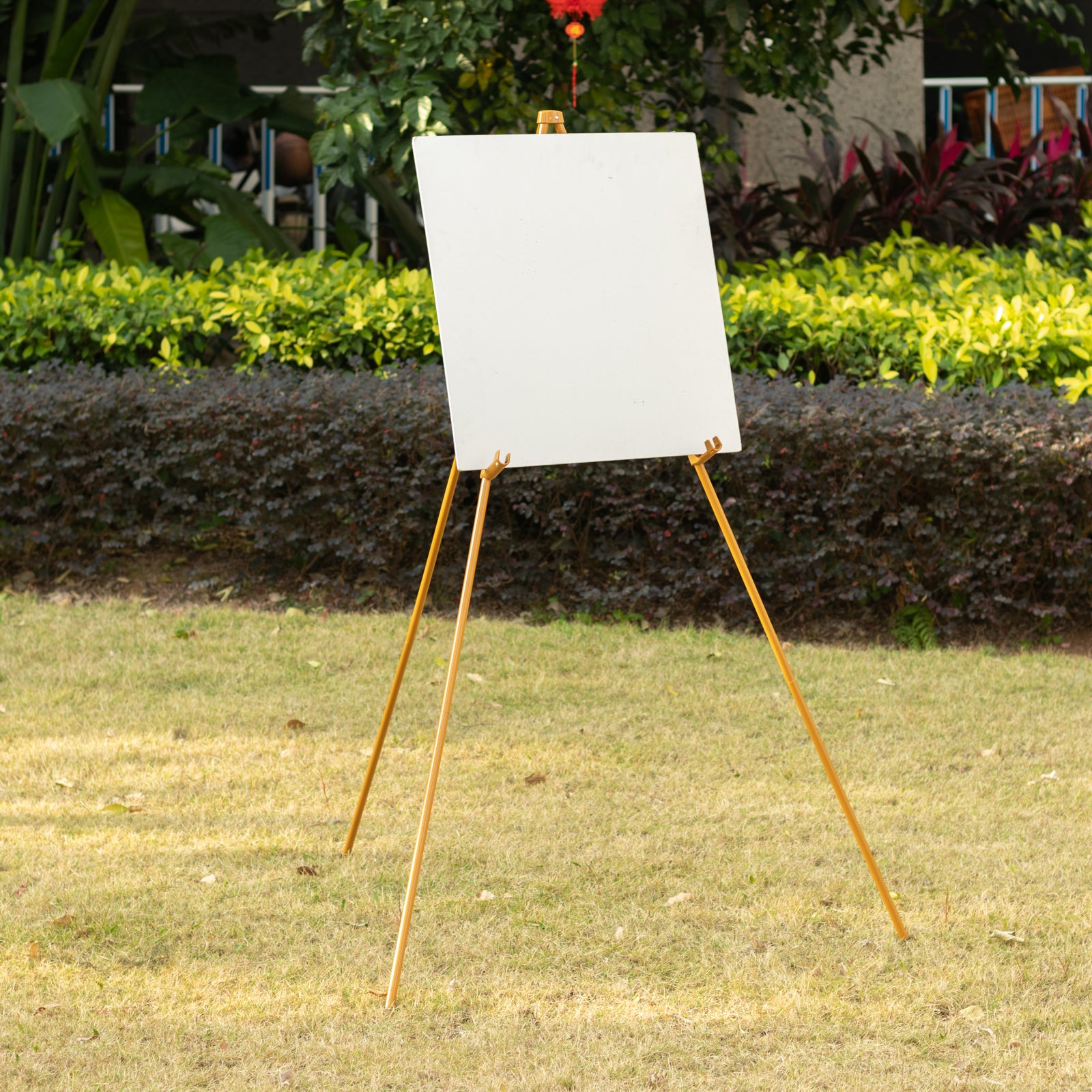 Gold metal easel stand for wedding signs and posters, adjustable and portable.