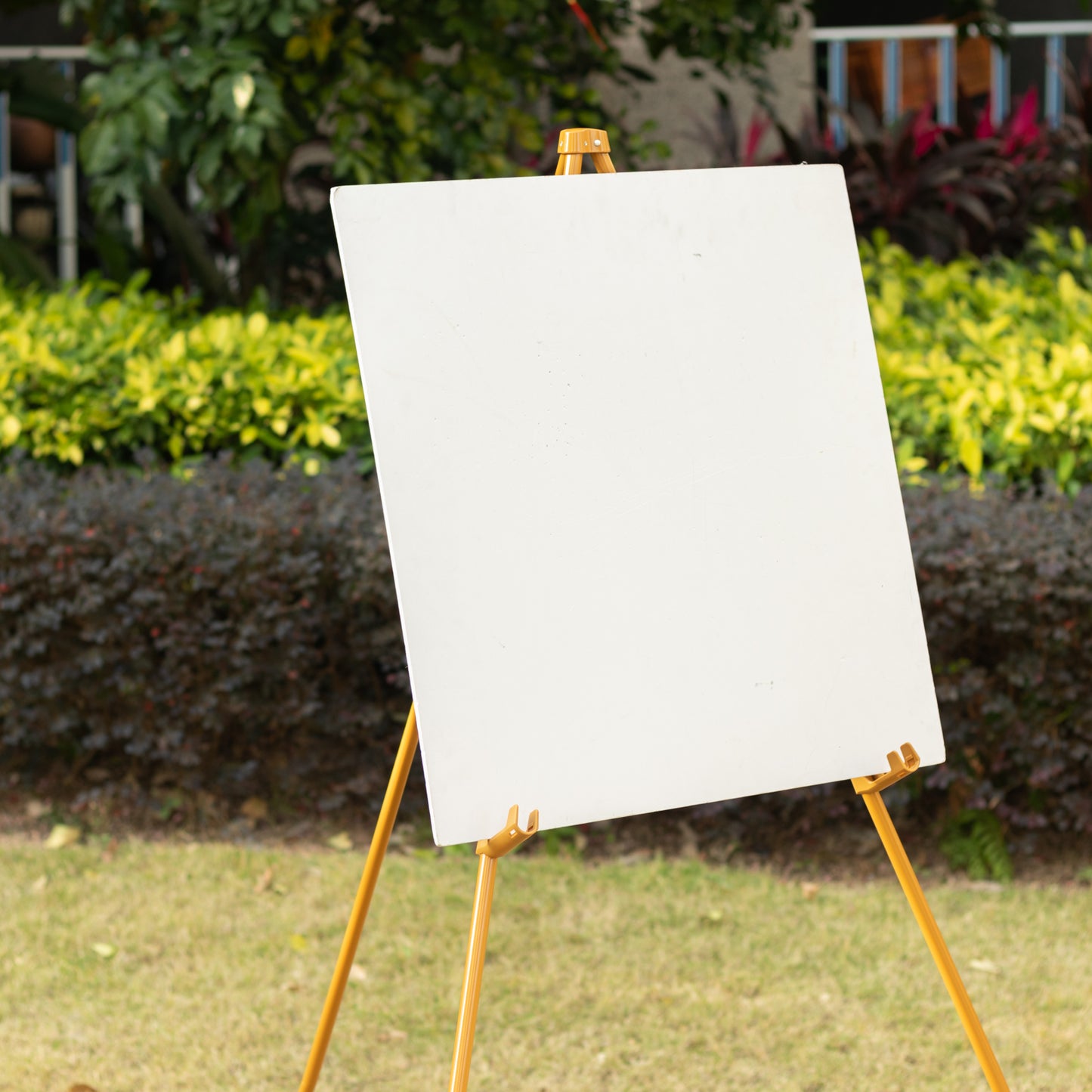 Gold metal easel stand for wedding signs and art, adjustable and portable.