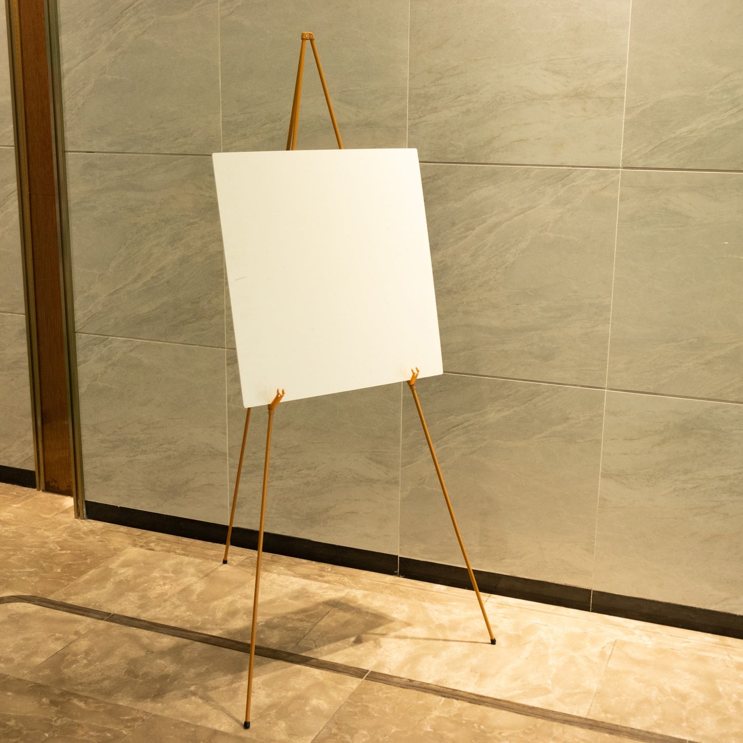 Gold metal sign holder easel stand, collapsible tripod design.