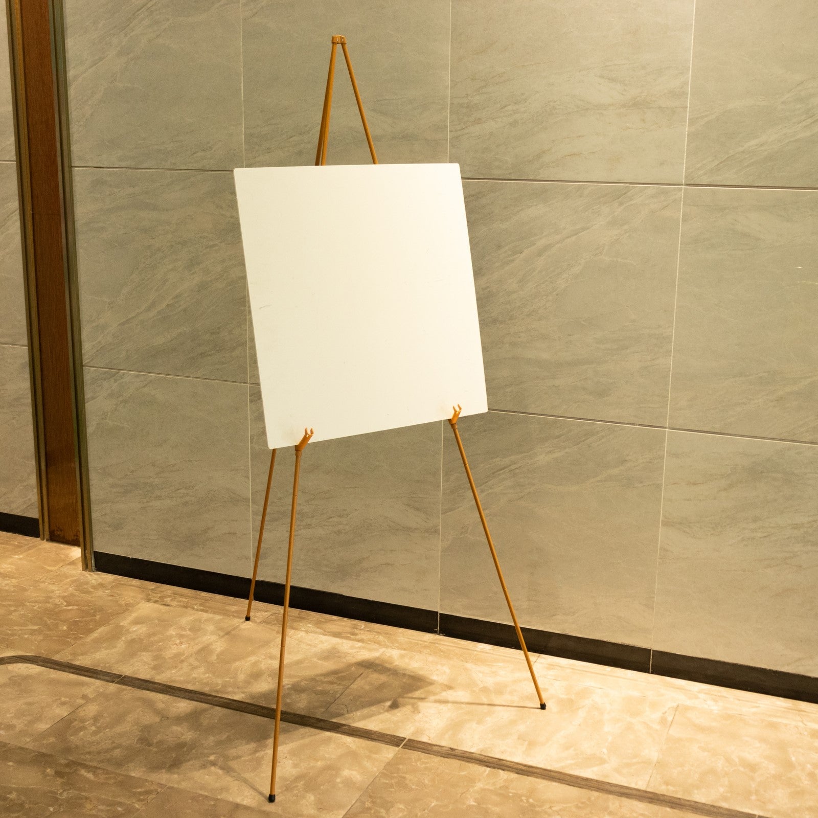 Gold metal sign holder easel stand, collapsible tripod design.