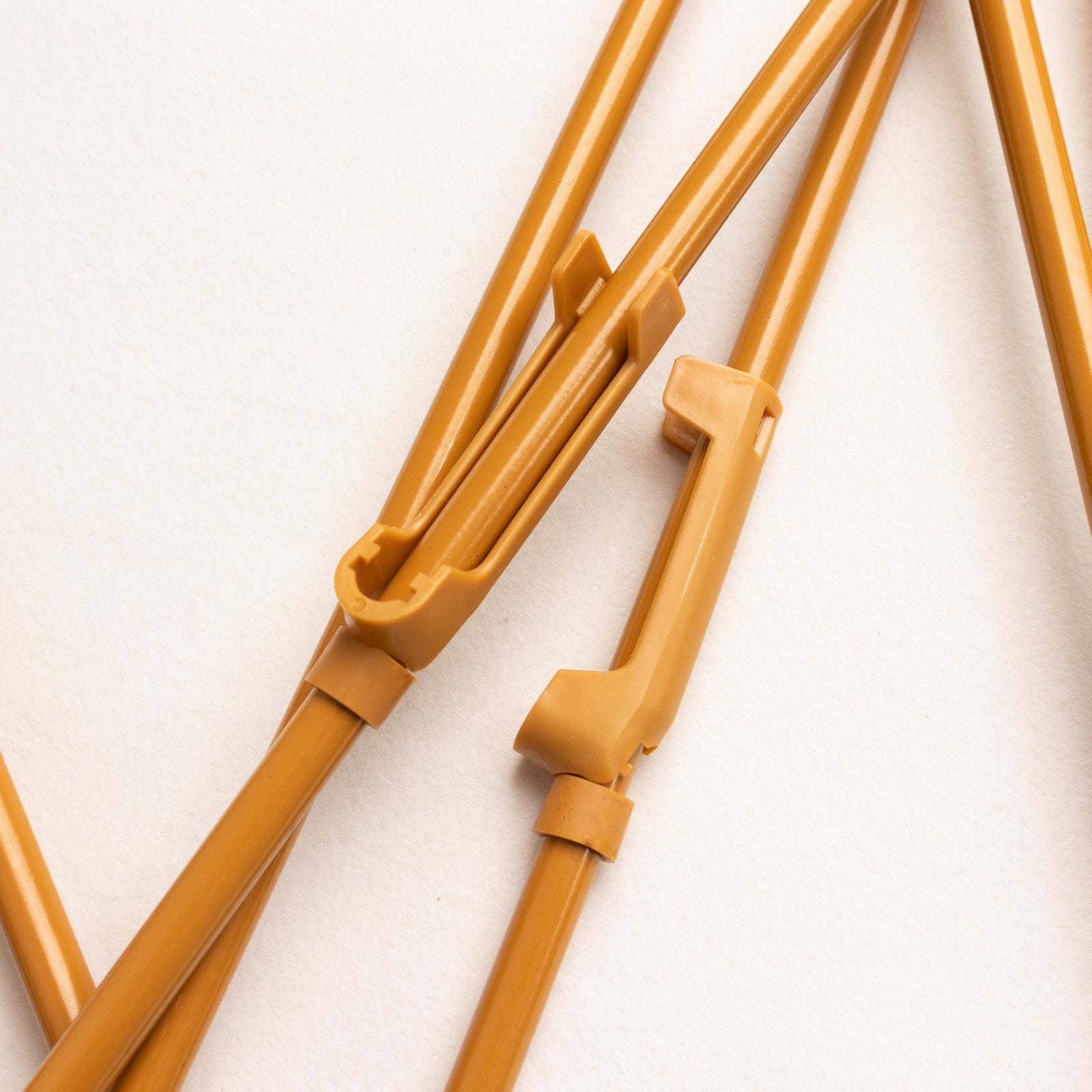 Gold metal easel stand with collapsible tripod design.