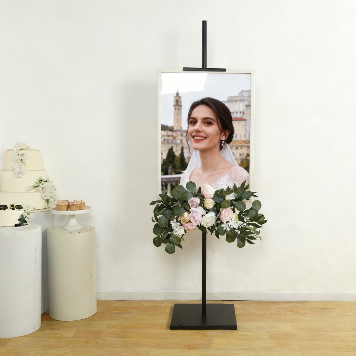 Black metal easel stand displaying artwork with floral decoration.