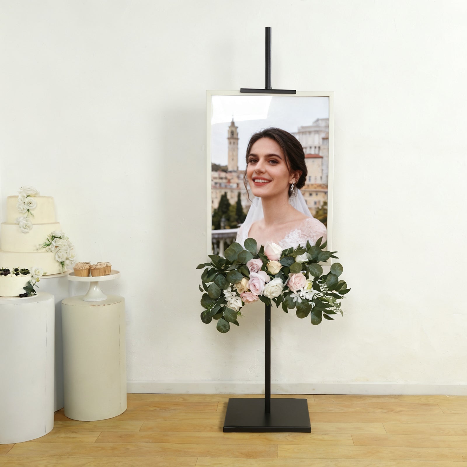 Black metal easel stand displaying artwork with floral decoration.