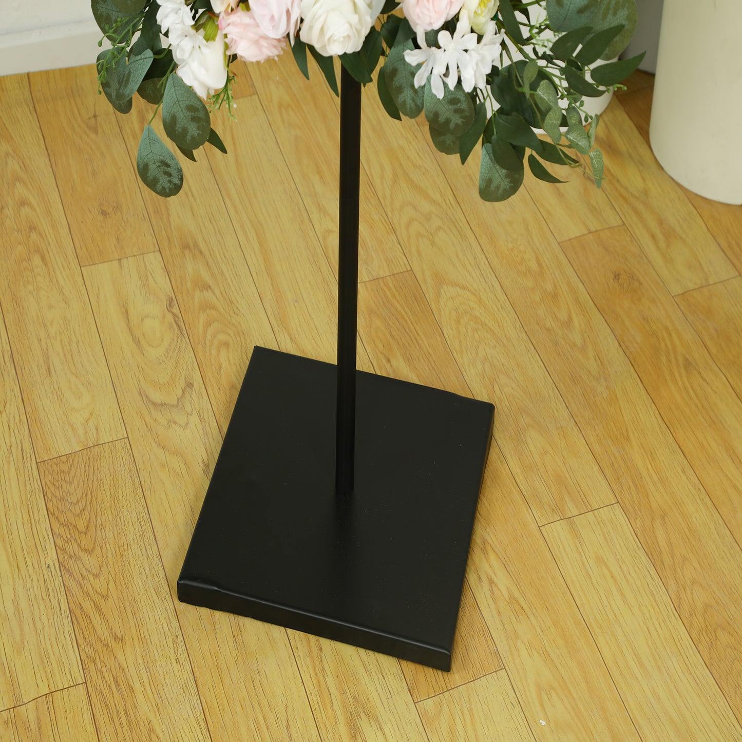 Black metal easel stand for displaying frames and artwork.