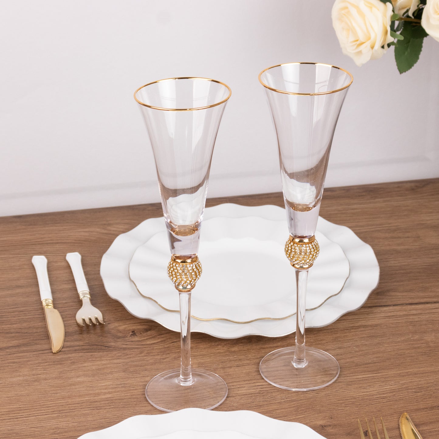 Gold rim crystal champagne flute glasses with studded rhinestones on a table setting.