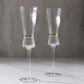 Clear champagne flutes with ribbed stem and gold ring accent. Elegant for celebrations.