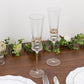 Clear champagne flutes with gold ring accents on a wooden table.