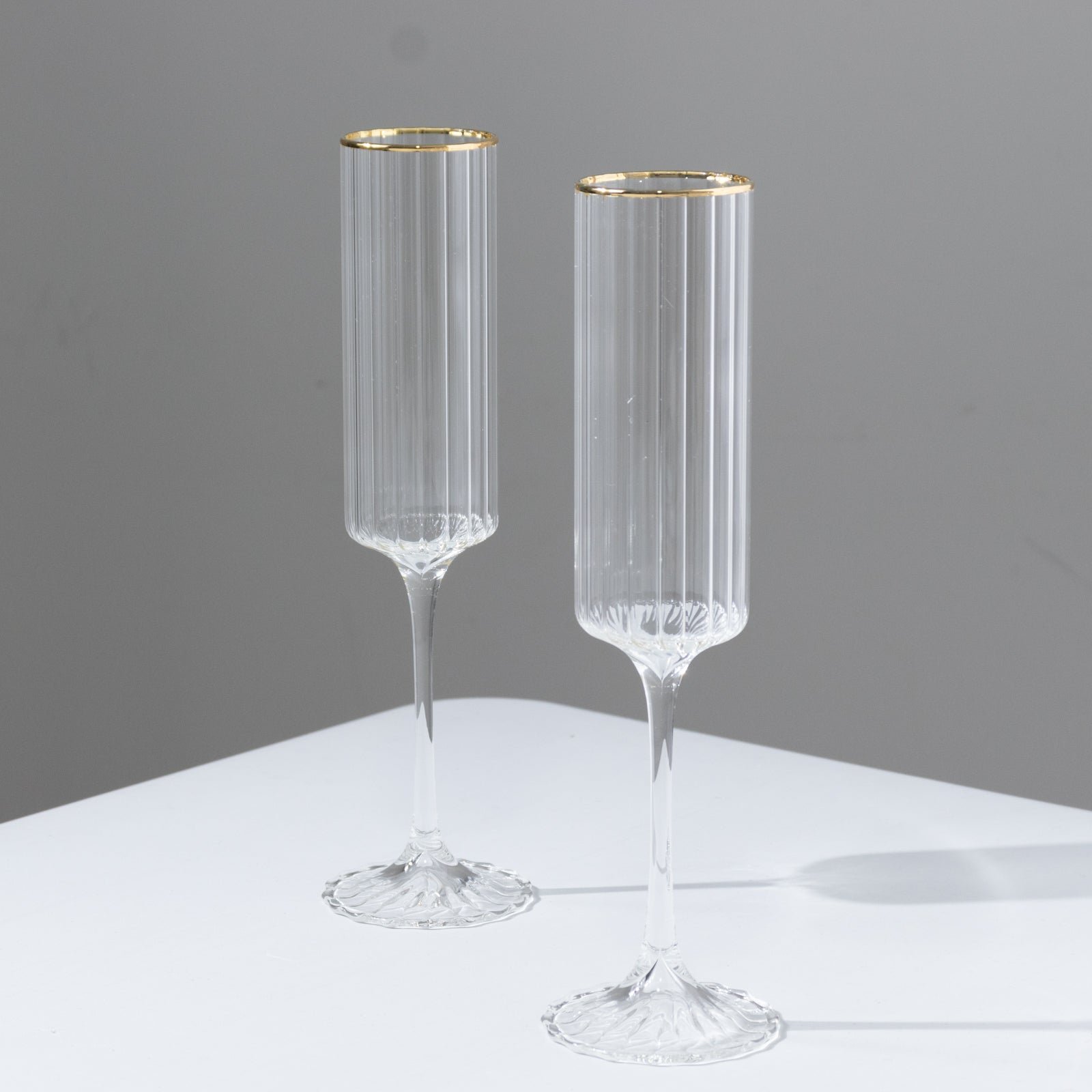 Clear modern champagne flutes with gold rim, elegant design for celebrations.