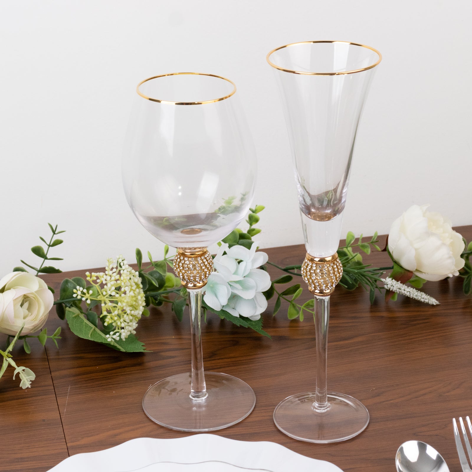 Gold rimmed crystal wine goblet glasses with rhinestone studded stems.