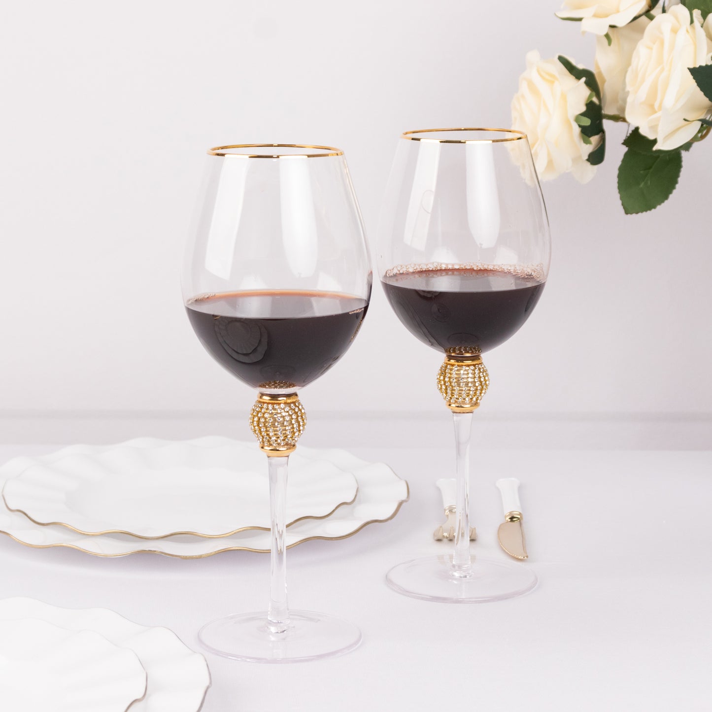 Gold rimmed crystal wine goblet glasses with rhinestone stems.