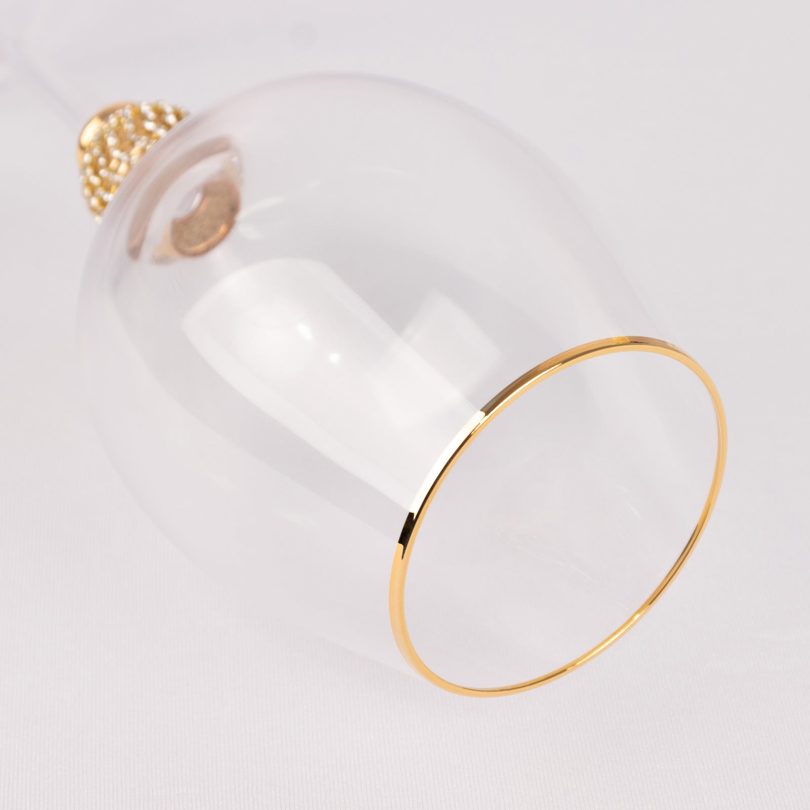 Gold rimmed crystal wine goblet glass with rhinestone studded stem.