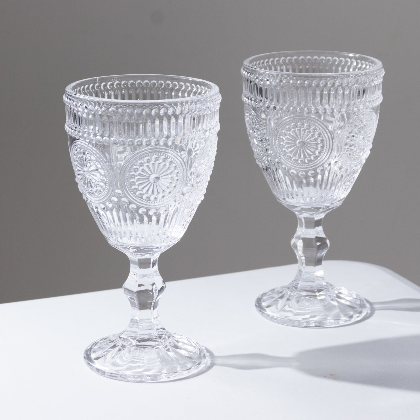 Clear vintage embossed goblets with floral design, perfect for cocktails and wine.