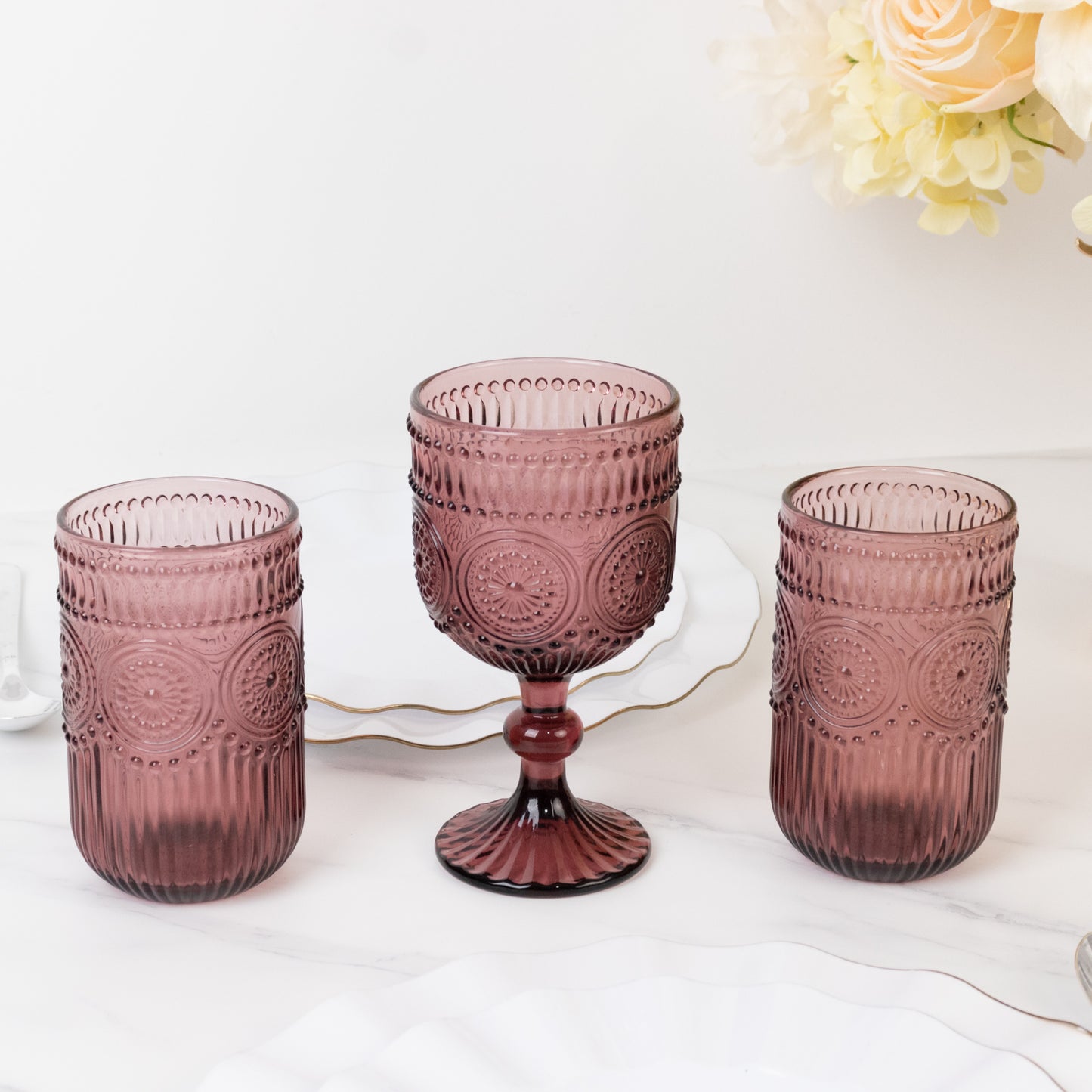 Dusty rose vintage embossed goblet wine glasses with floral pattern.