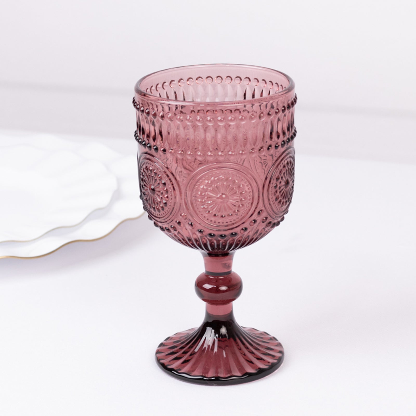 Dusty rose vintage embossed goblet wine glass with floral pattern.