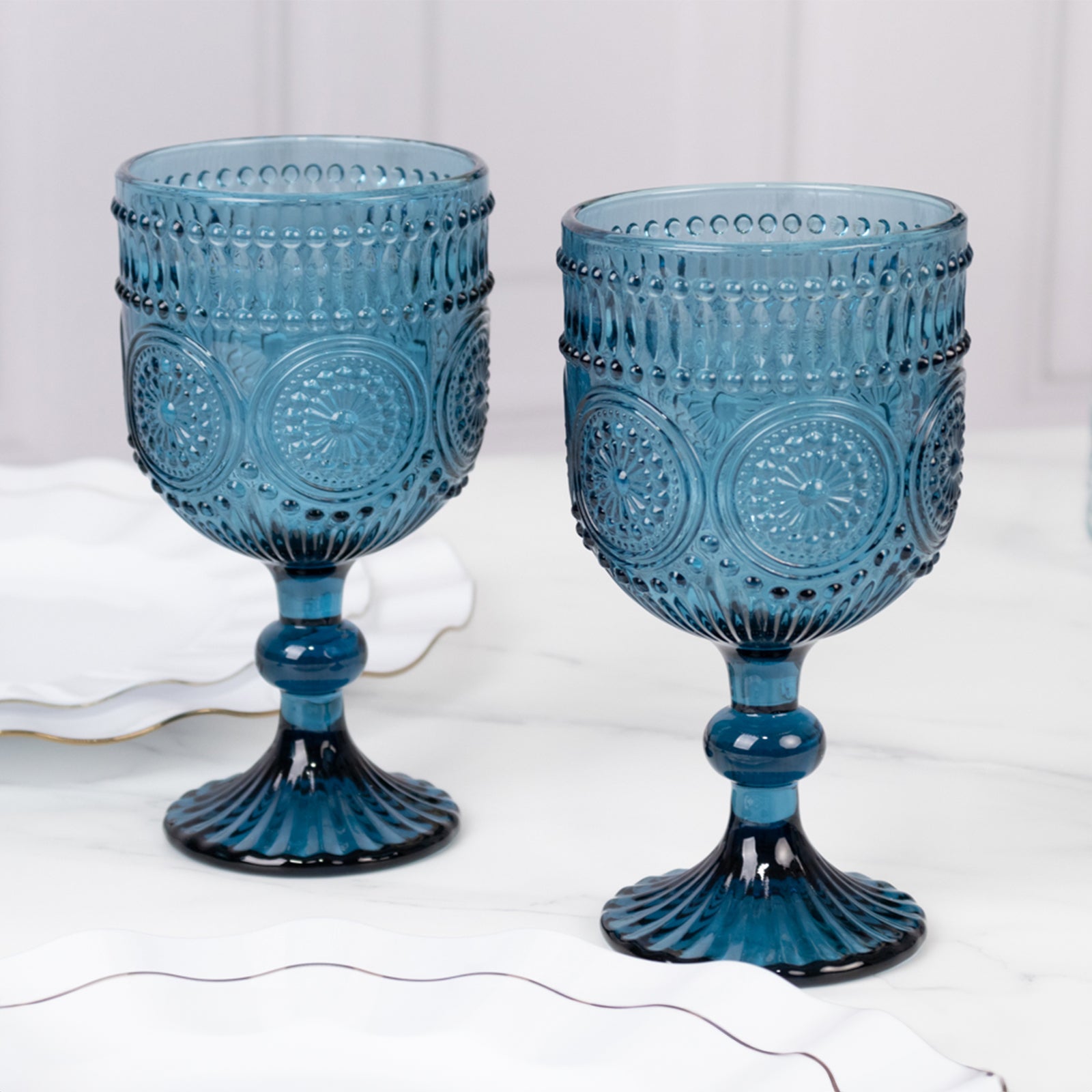Ocean blue vintage embossed goblet wine glasses with floral pattern.