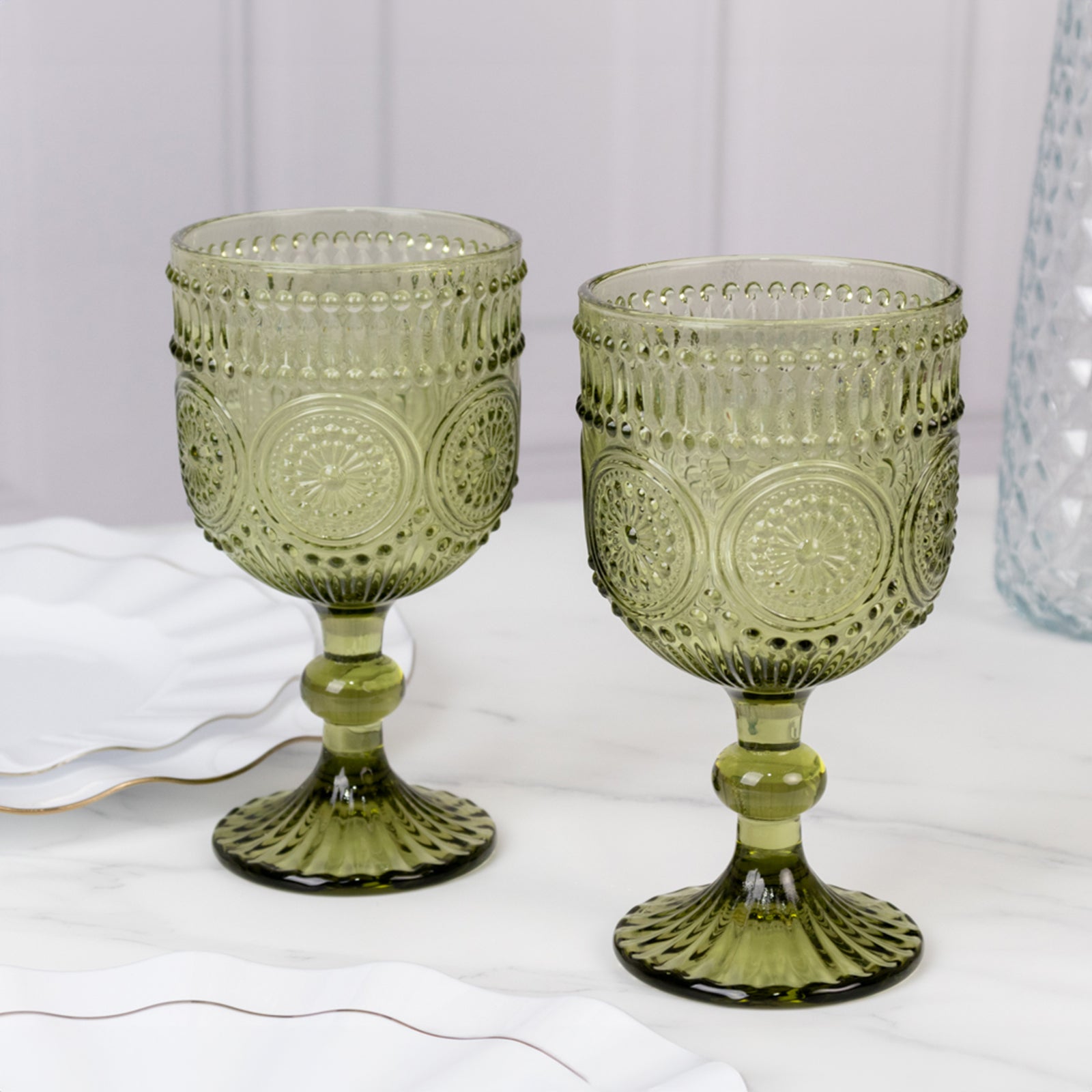 Dusty sage green vintage embossed goblet wine glasses with floral pattern.