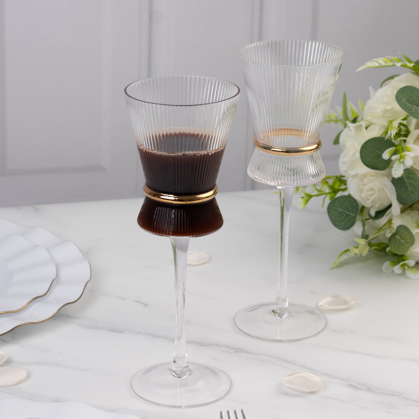 Clear wine glasses with ribbed design and gold ring accent. Elegant glassware for celebrations.