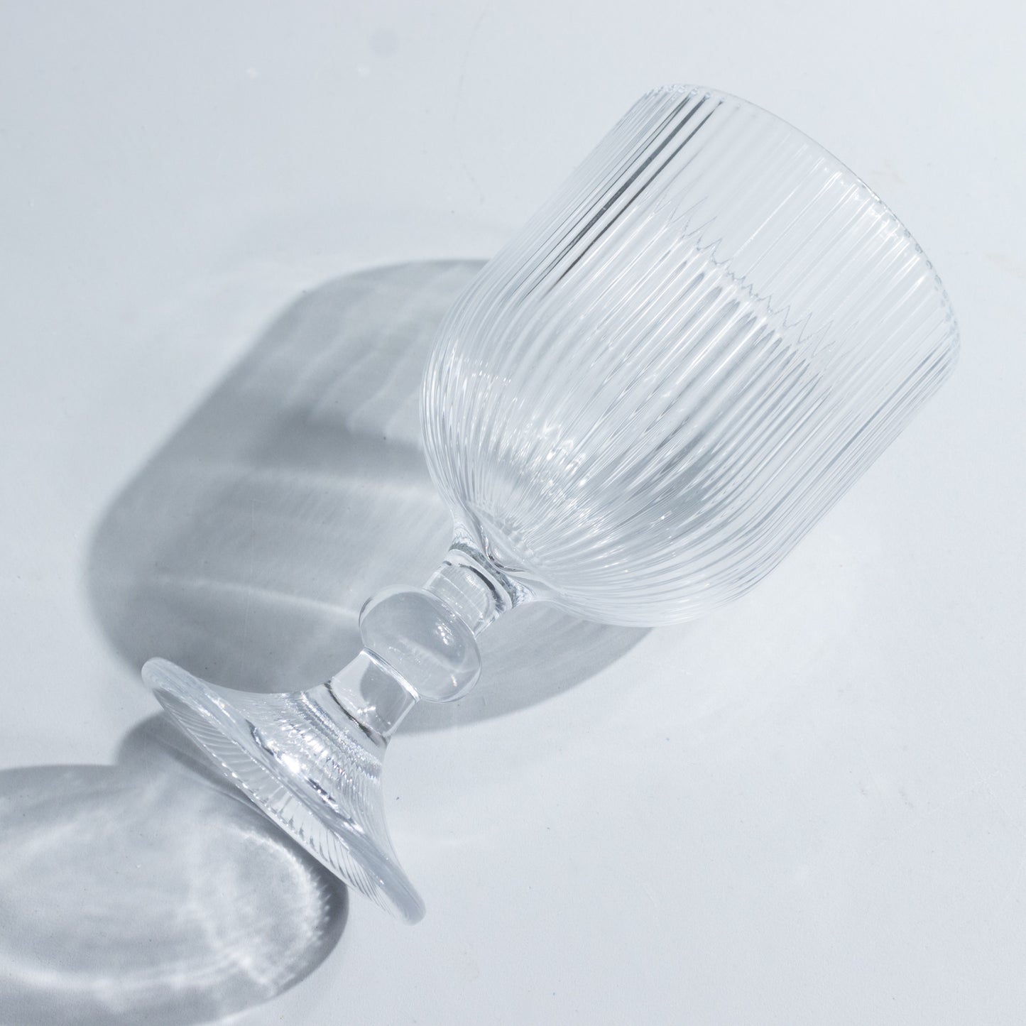 Clear vintage ribbed wine glass with ball stem accent.