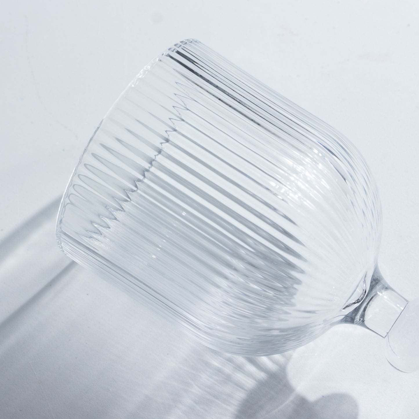 Clear ribbed wine glass with ball stem accent.