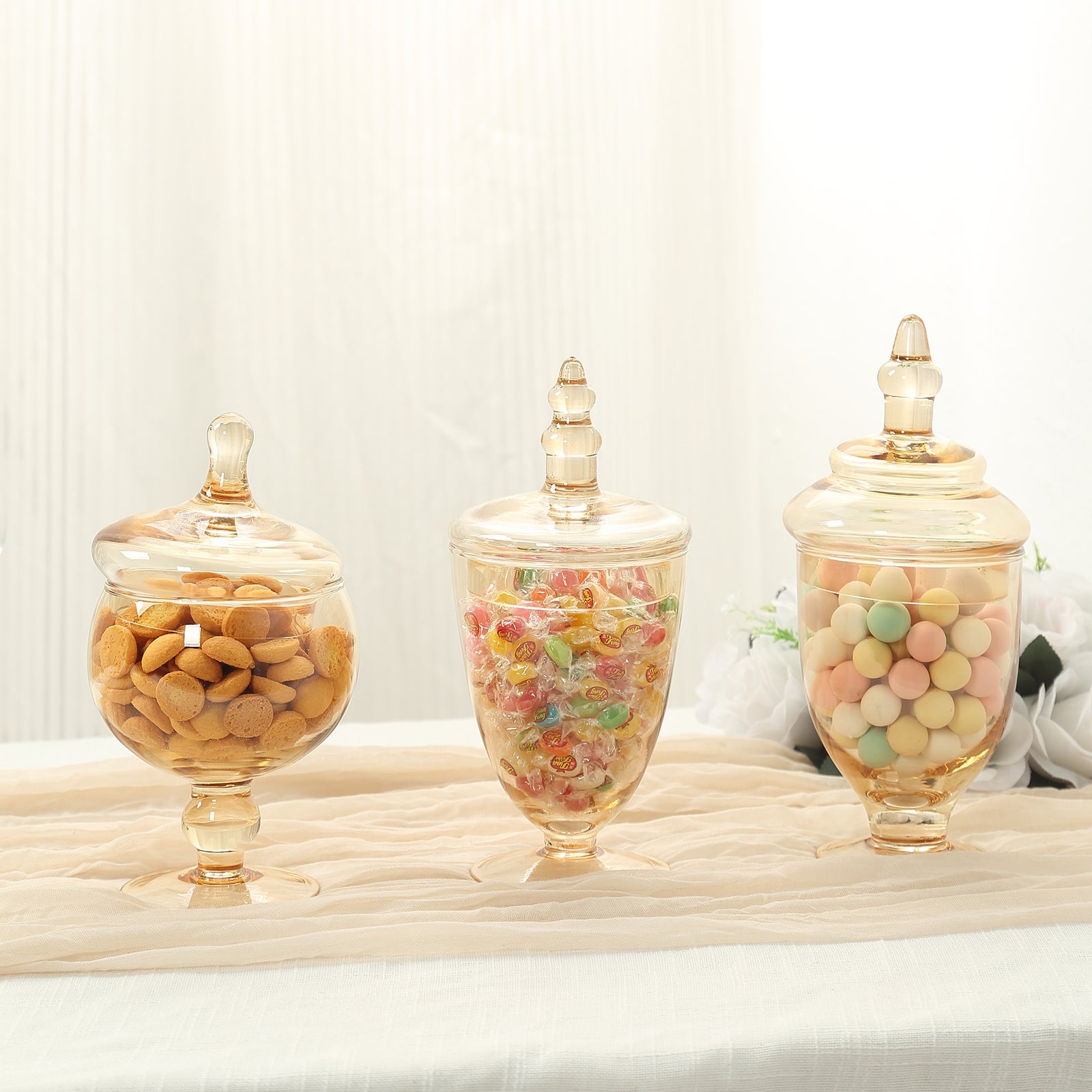 Amber gold decorative footed storage jars with snap-on lids.