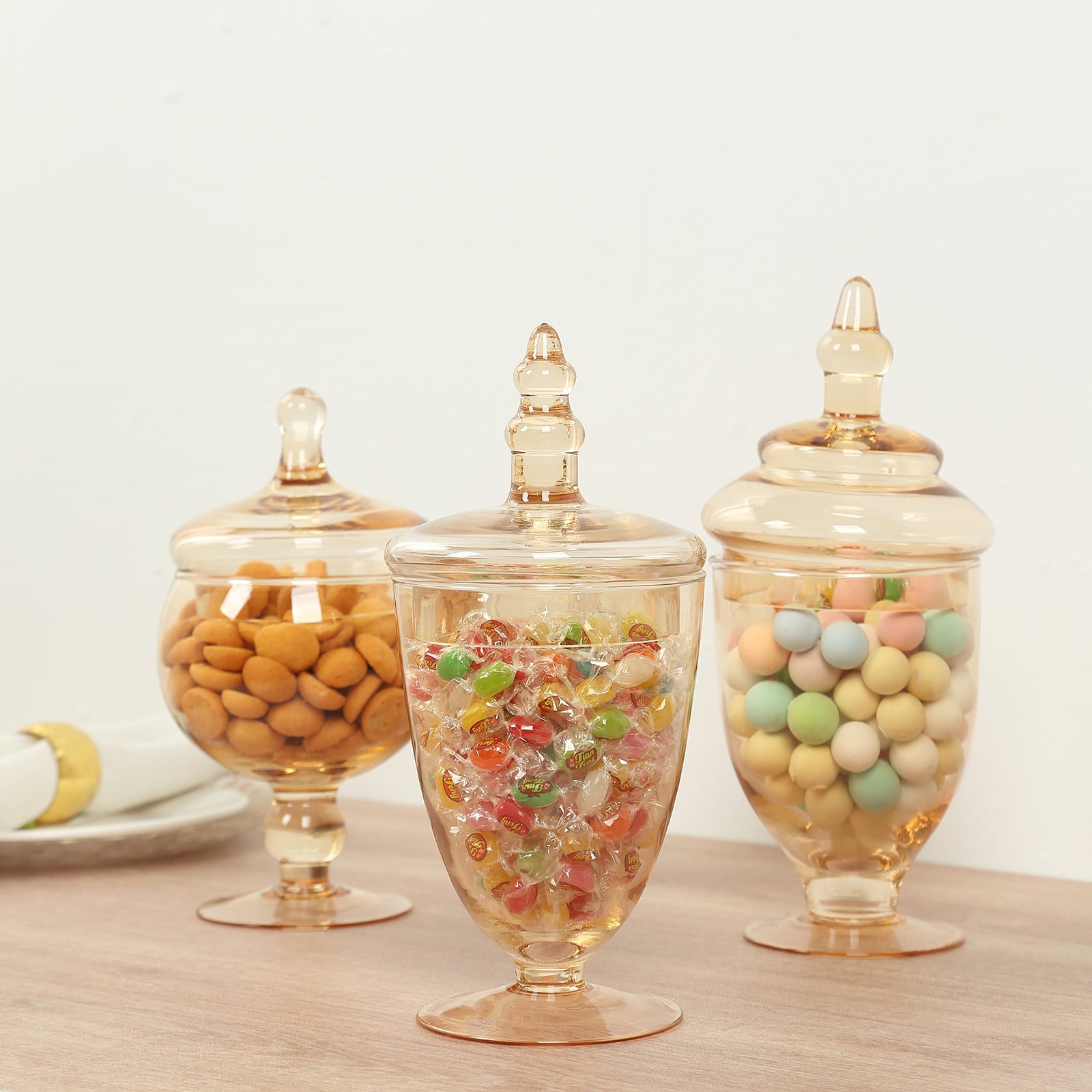 Amber gold decorative footed storage jars with snap-on lids.