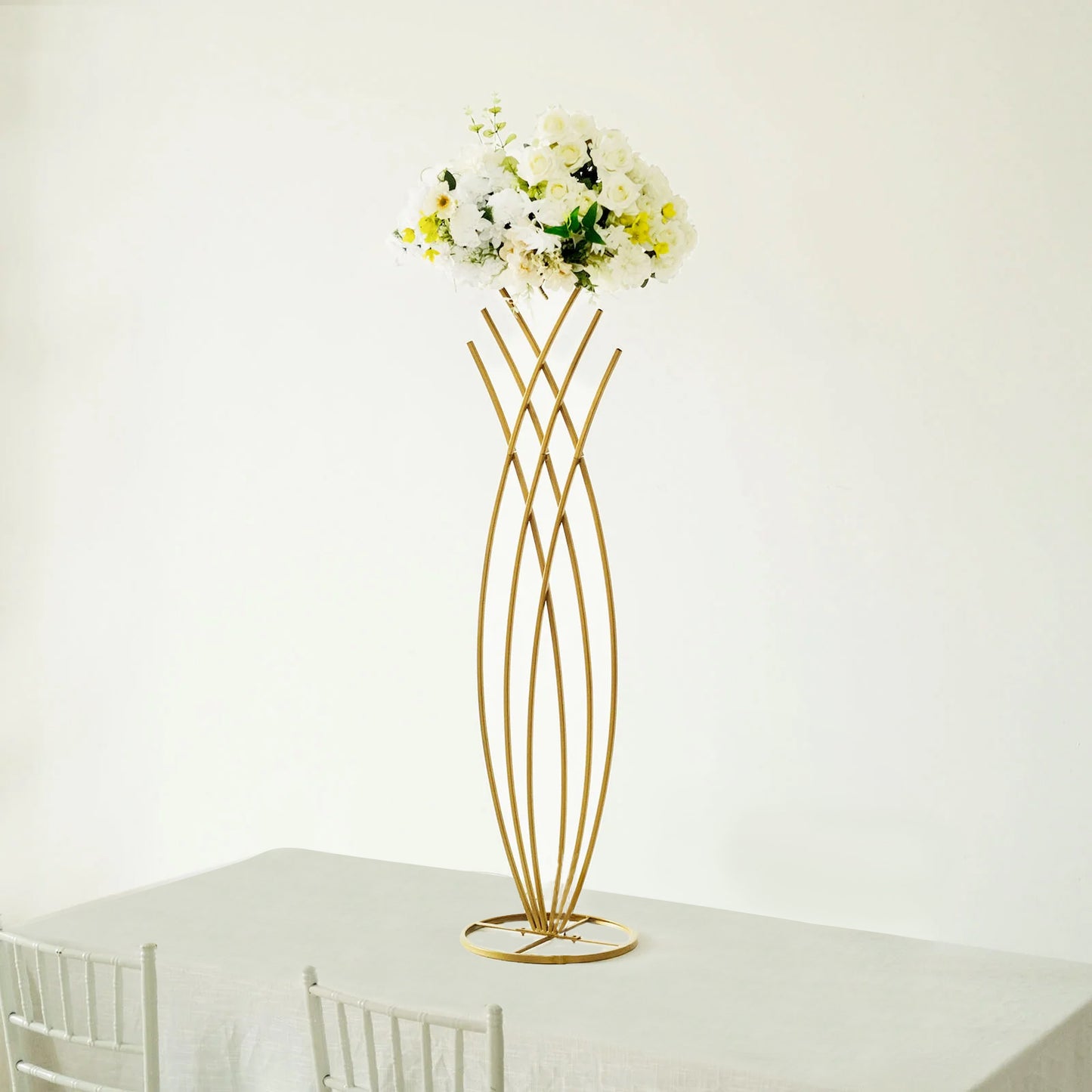 Gold metal mermaid tail flower frame centerpiece with white floral display.