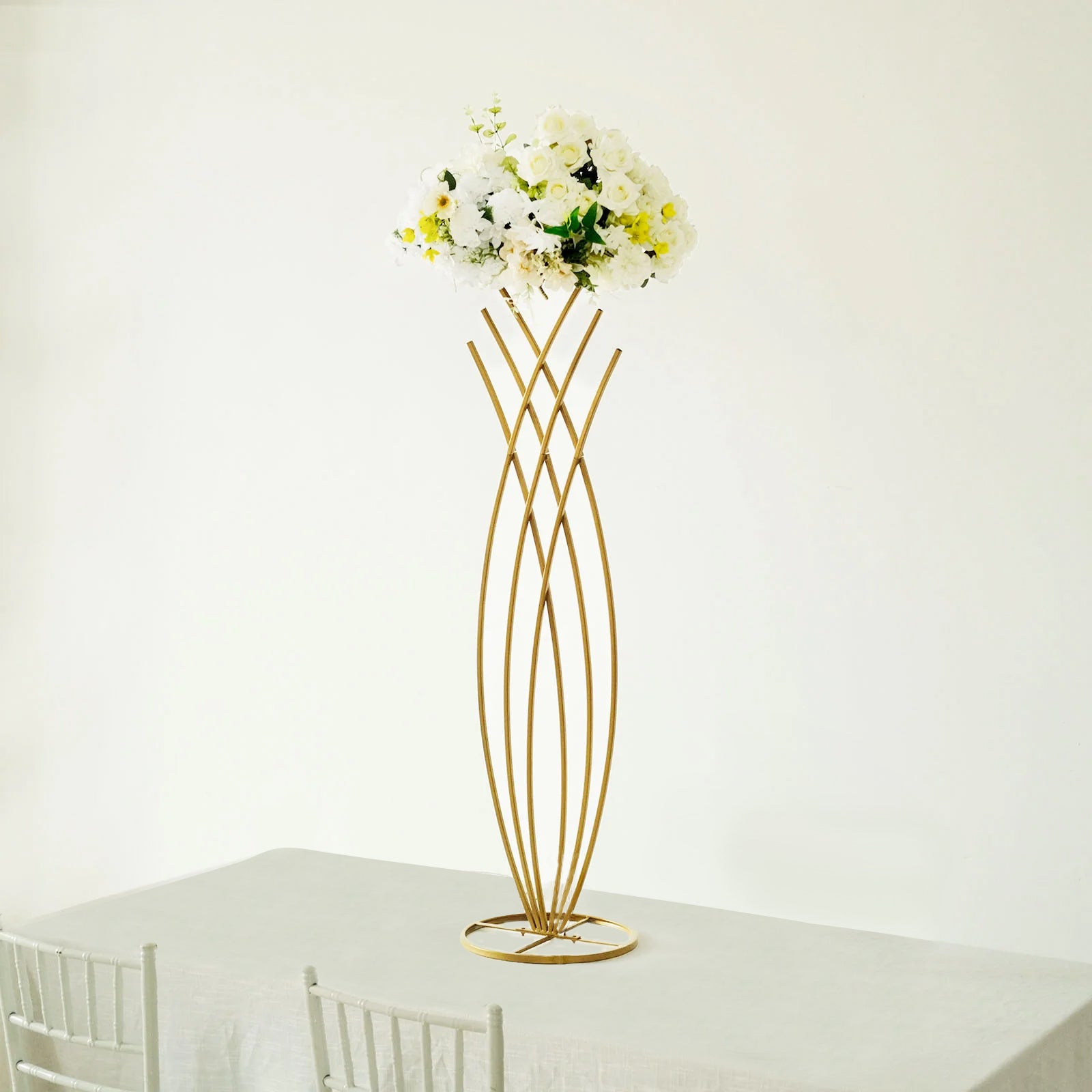 Gold metal mermaid tail flower frame centerpiece with white floral display.