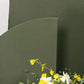 Dusty sage green spandex wedding arch cover with floral decor.