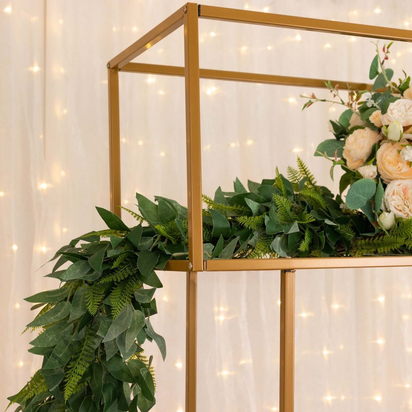 Gold floral arrangement tabletop display rack with greenery and floral accents.