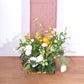 Rose gold shimmer tinsel backdrop with floral arrangement at base.