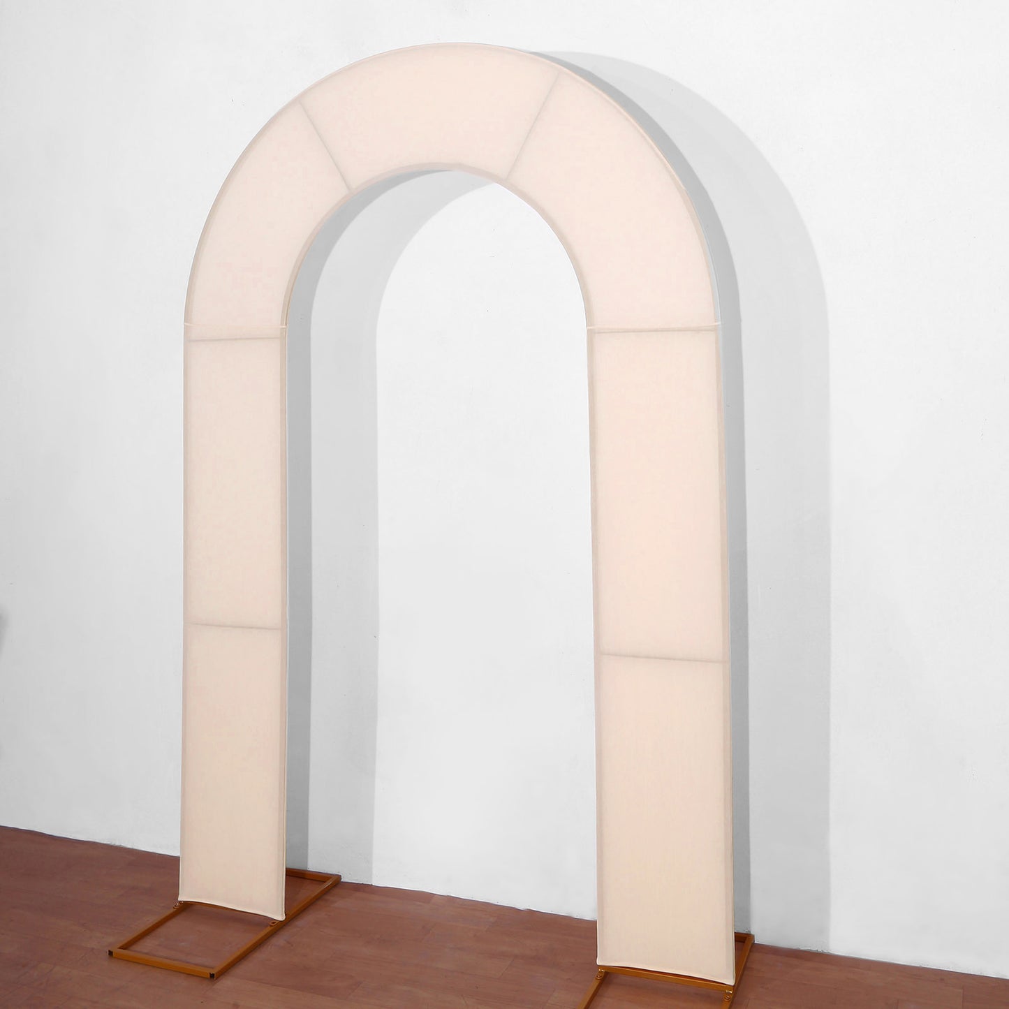 Blush spandex fitted wedding arch cover on a simple backdrop.