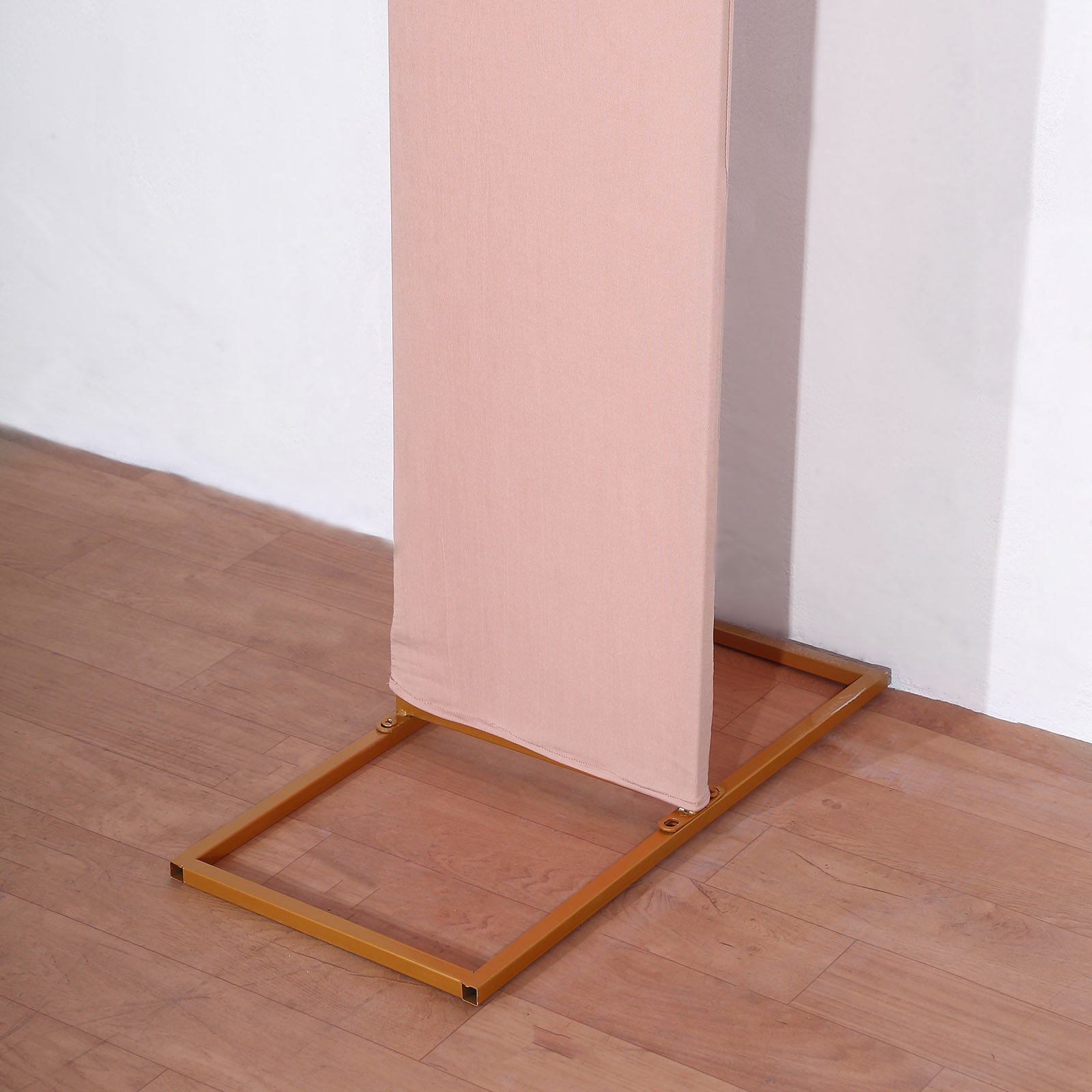 Dusty rose spandex fitted wedding arch cover on a gold frame.