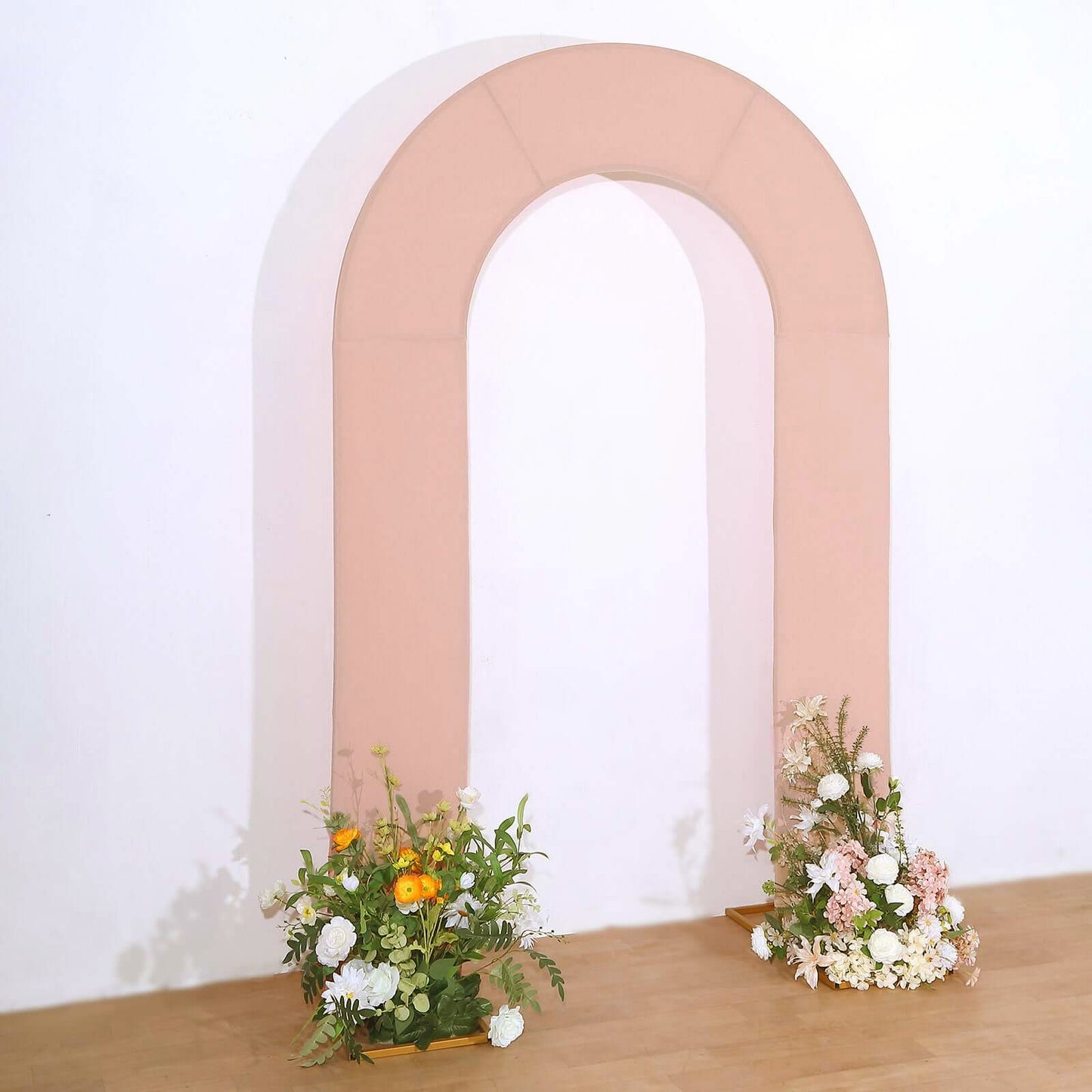 Dusty rose spandex fitted wedding arch cover with floral arrangements.