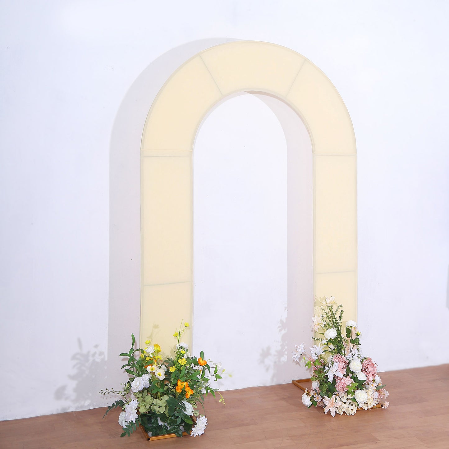 Beige spandex fitted wedding arch cover with floral arrangements.