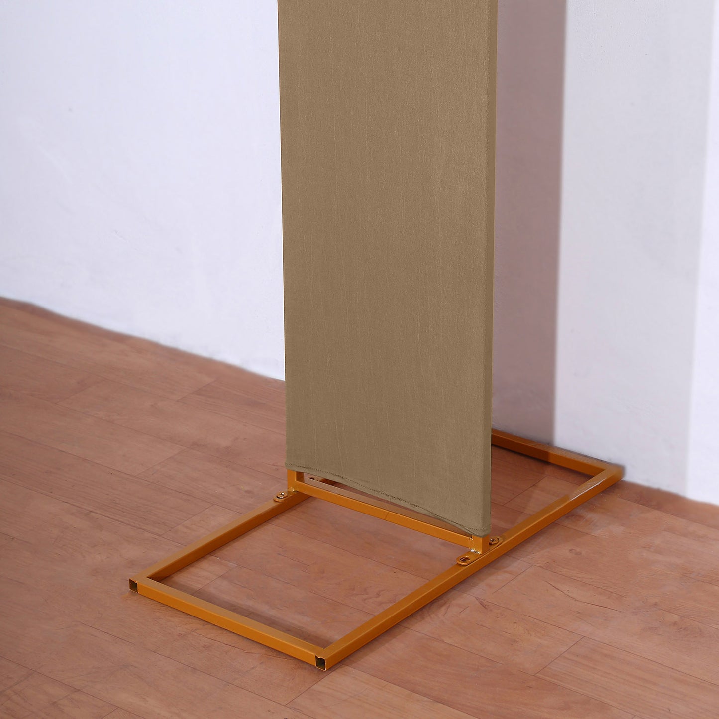 Taupe spandex fitted wedding arch cover on a gold frame.