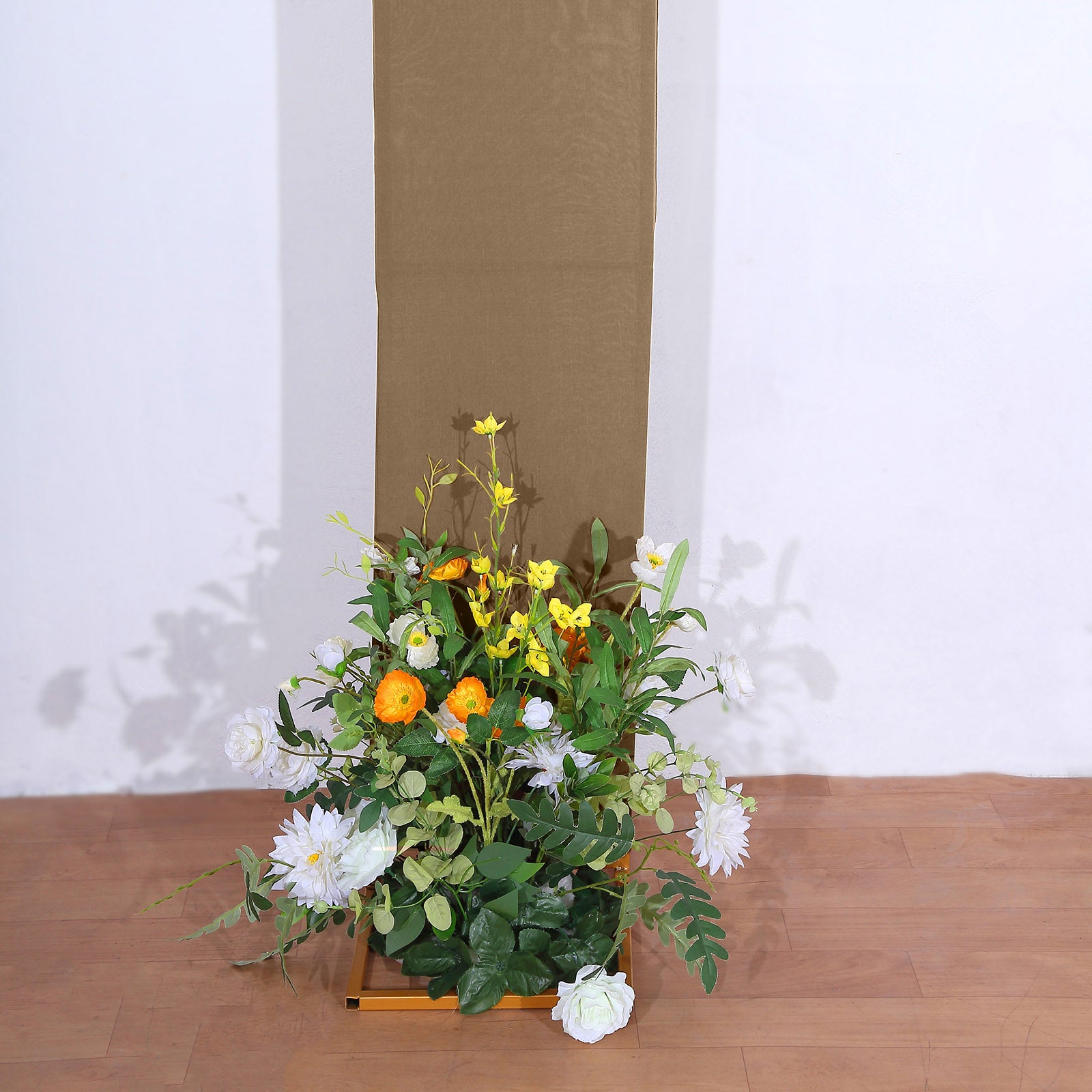 Taupe spandex fitted wedding arch cover with floral arrangement.