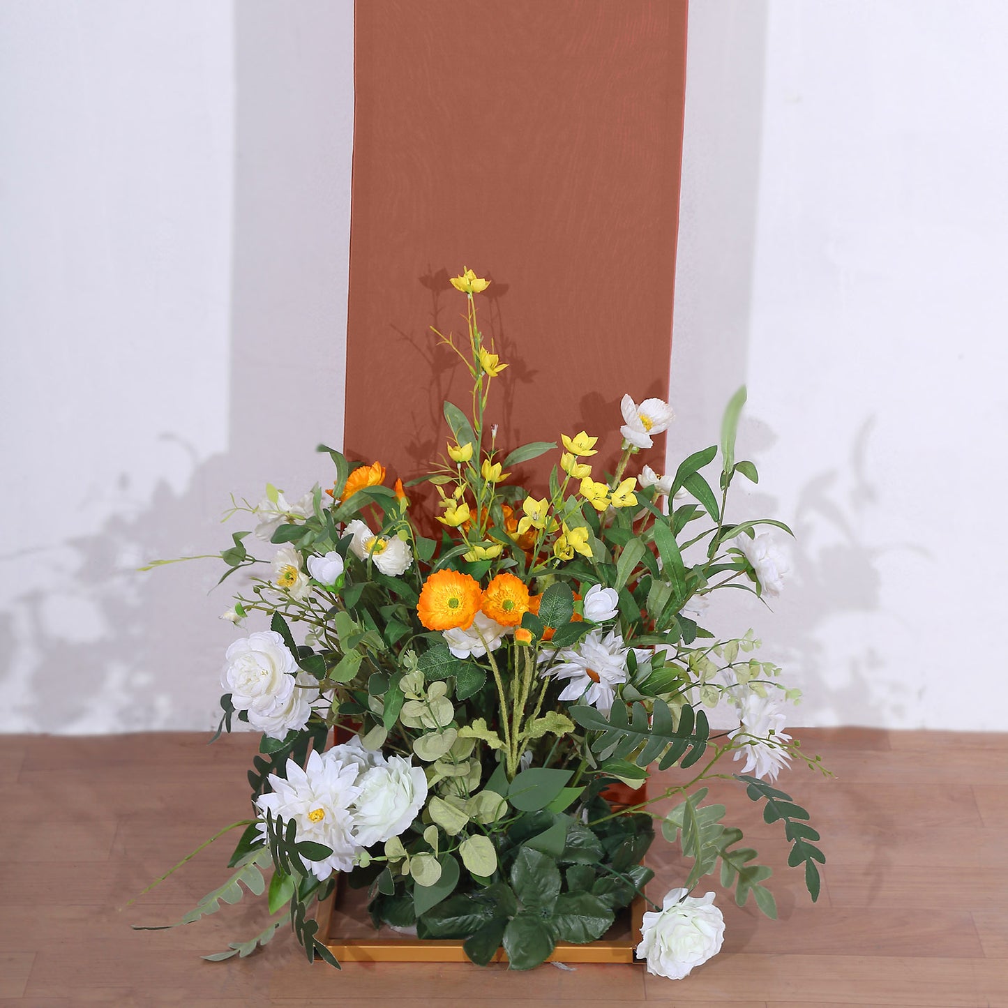 8ft terracotta spandex wedding arch cover with floral arrangement at the base.