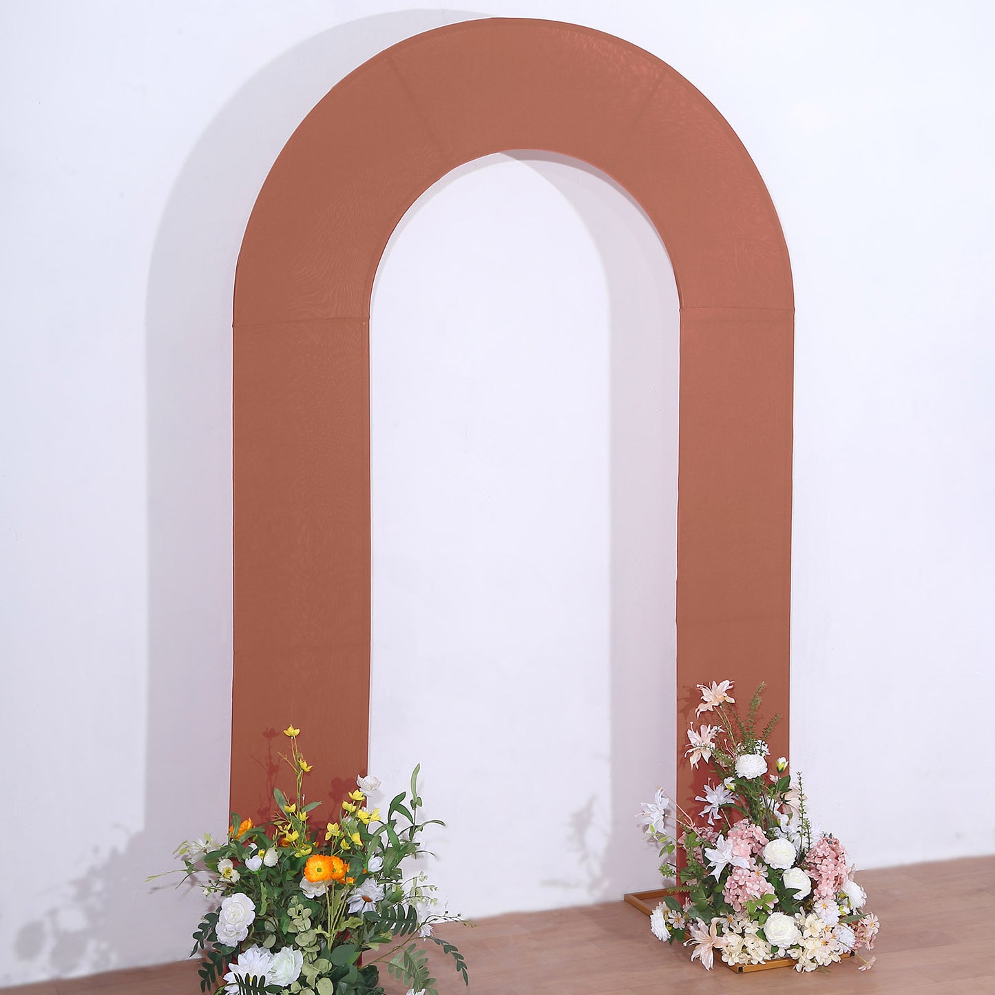 8ft rust spandex fitted wedding arch cover with floral arrangements.