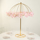 Gold metal umbrella flower stand with pink floral accents.