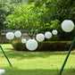 Set of 8 ivory hanging paper lanterns in assorted sizes.