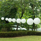 Set of 8 ivory hanging paper lanterns in assorted sizes.