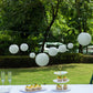 Set of 8 ivory hanging paper lanterns in assorted sizes.