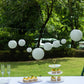 Set of 8 ivory hanging paper lanterns in assorted sizes.