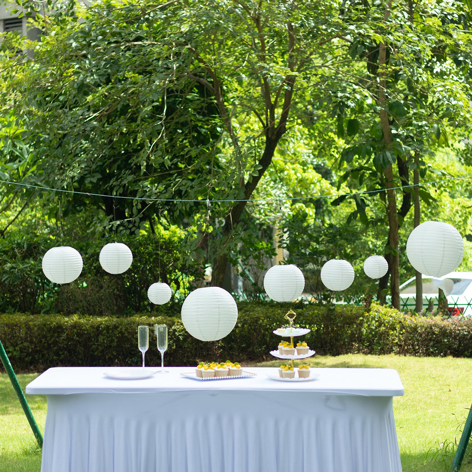 Set of 8 ivory hanging paper lanterns in assorted sizes, perfect for decoration.